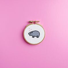 a small cross stitch elephant on a pink background