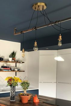 a wooden table topped with two vases filled with yellow and orange flowers on top of a hard wood floor