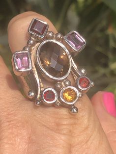 Amazing unique big gemstone ring smoky quartz, amethyst, Garnet and citrine. Ring sterling silver 925 Queen/ Royal Statement Size 10. Amazing ring. Extremely unique, I've never seen one like it. It truly feels like a medieval piece of jewelry that a queen or king would wear. Unusual and abstract piece. Would be perfect for a statement piece or even a Renaissance fair. The ring is well-made and solid. Signed 925. Unique Multi-stone Citrine Rings, Unique Multi-stone Topaz Jewelry, Unique Silver Topaz Gemstone Ring, Unique Multi-stone Amethyst Ring For Anniversary, Unique Multi-stone Amethyst Ring For Gift, Unique Citrine Rings With Accent Stones, Unique Multi-stone Amethyst Ring In Sterling Silver, Unique Amethyst Ring With Accent Stones, Citrine Jewelry Stamped 925