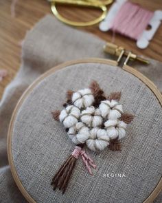 a close up of a embroidery on a piece of cloth with scissors in the background