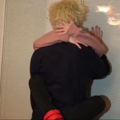 a man with blonde hair hugging another person