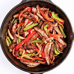 a skillet filled with steak and peppers