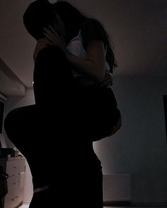 a man and woman are hugging in the dark