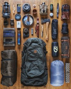 the contents of a backpack laid out on a wooden floor next to some other items