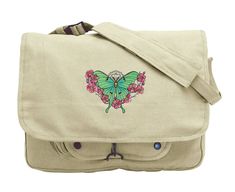 "Painterly details bring this floral Luna Moth to life. Luna Moth design embroidered on canvas messenger bag. Vintage Canvas Messenger Bag offers classic styling and functionality and features 3 inner compartments great for storage of books or gear, 1 outer compartment w/ snaps and a fully adjustable shoulder strap. Size: One Size 15\"W x 11\"H x 4\"D. Design size: 6.85\"(w) x 4.84\"(h) Strap is approx 40\" from end to end when fully extended Colors of thread in embroidery design, along with mat Embroidered Canvas Shoulder Bag For Travel, Embroidered Cotton Shoulder Bag For Travel, Embroidered Beige Shoulder Bag For School, Beige Embroidered Shoulder Bag For School, Embroidered Cotton Shoulder Bag For School, Hogwarts Bag, Luna Moth Design, Slytherin Crest, Moth Design