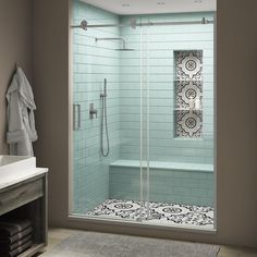 a bathroom with a walk in shower next to a white sink and a blue tiled wall