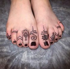 two feet with different designs on them and one has a black nail polish in the middle