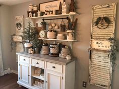 a kitchen with white cabinets and shelves filled with dishes