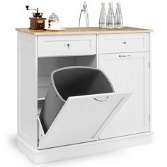 an open dishwasher sitting on top of a white cabinet next to a counter