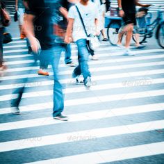 blurry image of people walking across a crosswalk at an intersection in the city