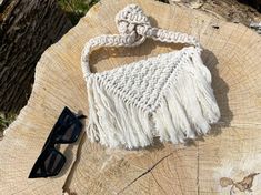 a white purse sitting on top of a tree stump