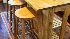 three wooden stools sit at the center of a kitchen island in front of an area rug