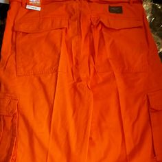 Akademiks Orange Cargo Shorts Spring Bermuda Bottoms With Multiple Pockets, Casual Orange Bottoms With Side Pockets, Casual Orange Bottoms With Pockets, Orange Bottoms With Pockets For Outdoor, Orange Bottoms With Pockets Short Length, Casual Orange Short Bottoms, Casual Orange Shorts With Pockets, Orange Cargo Pants For Summer, Casual Orange Bottoms With Cargo Pockets