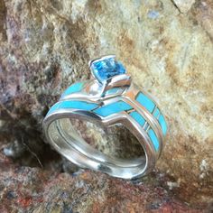 This beautiful Sterling Silver Ring Set, as part of the Arizona Blue Collection features Kingman Turquoise with a Blue Topaz. Engagement Ring Width: Top 5/8"; Shank 1/8" Band Width: 1/4"; Shank 1/8" The ring is designed by David Rosales, one of the finest contemporary Southwest Artists in the world. He is the founder and co-owner of Supersmiths, Inc. of Gallup, NM. Each ring is custom made and carries a lifetime guarantee. Turquoise Sterling Silver Jewelry With Center Stone, Turquoise Topaz Ring With Accent Stones In Sterling Silver, Turquoise Jewelry With Gemstone Accents For Promise Ring, Turquoise Gemstone Jewelry For Promise Ring, Blue Sterling Silver Rings With Accent Stones, Blue Multi-stone Aquamarine Jewelry, Blue Aquamarine Multi-stone Jewelry, Sterling Silver Turquoise Topaz Ring, Blue Turquoise Ring With Gemstone Accents In Sterling Silver