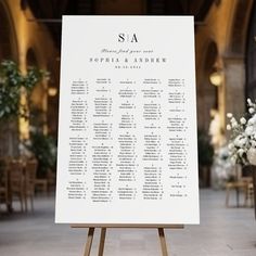 a seating chart for a wedding in an old building with white flowers and greenery