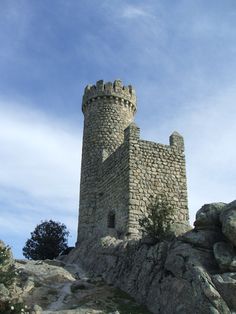 an old stone castle sitting on top of a rocky hill