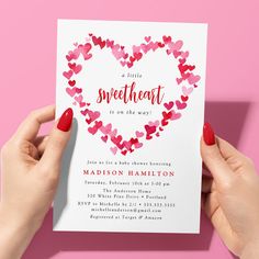 two hands holding up a card with hearts in the shape of a heart on it