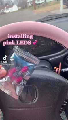 someone is holding up the pink leds in their car's steering wheel cover