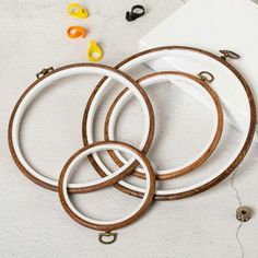 three wooden hoops are sitting on the floor next to some beads and other items