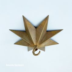 a brass star shaped object with a ring hanging from it's side