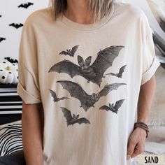 Vintage Bat Halloween Shirt | Goblincore Shirt | Grungy Gothic Graphic Tee  Bat Sweatshirt -> https://bit.ly/44hhWeA   This is a unisex shirt - if you would like an oversized tee, size up one or two sizes to get the desired look. If you want a tighter fit, go for a size down - have a look at the size guide in the listing to compare sizes.  T-shirt Details   *PLEASE READ*  * 100% Cotton (Fiber content may vary for different colors) * Gildan Unisex Short Sleeve Heavy Cotton Tee  * Classic Fit  * P Witchy Graphic Tees, Fall Goblincore Crew Neck T-shirt, Halloween Fairy Grunge T-shirt With Crew Neck, Fairy Grunge Halloween T-shirt With Crew Neck, Fairy Grunge Halloween Crew Neck Top, Fairy Grunge Crew Neck Top For Halloween, Halloween Long Sleeve Fairy Grunge Tops, Halloween Fairy Grunge Long Sleeve Tops, Fairy Grunge Long Sleeve Halloween Tops