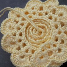 a crocheted flower is shown on a table