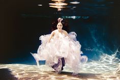 a woman in a white dress under water