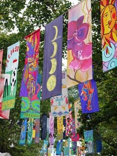 many colorful flags are hanging from the trees