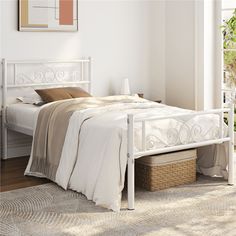 a white bed sitting in a bedroom on top of a wooden floor next to a window