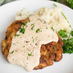 a close up of a plate of food with mashed potatoes and gravy