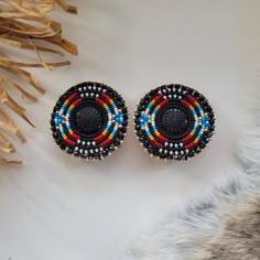 two pairs of beaded earrings sitting on top of a fur rug