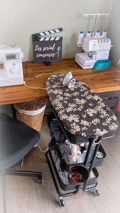 an ironing board sitting on top of a wooden table next to a sewing machine