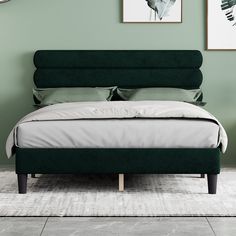 a bed with green headboard and pillows in a room that is painted mint green