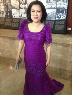 a woman in a purple dress posing for the camera