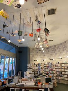 a room filled with lots of books and hanging lights