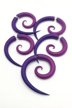 four purple and purple spiral earrings on a white background