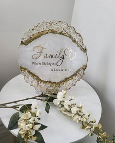 a white table topped with flowers and a personalized glass plate on top of it