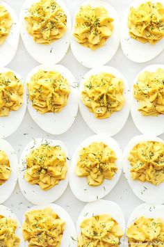 several plates filled with pasta and garnished with herbs on white paper lined up in rows