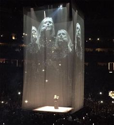 the stage is lit up with lights and curtains on it, while two women stand in front of them