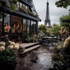 the eiffel tower is seen in the distance from an outdoor patio with tables and chairs