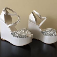 a pair of white wedges with silver sequins on the heel and straps