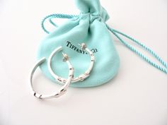 Offered for sale is a pair of Tiffany and Co. Sterling Silver Signature X Hoop Earrings. The style is classic Tiffany, making it a piece that you will most certainly use over and over again. Great piece to wear to work, or for just going to dinner with friends in jeans or a pretty dress. Super versatile and chic piece! It's like a piece of art - right on your ears! A wonderful Tiffany piece to start or add to your collection. As always, the item is fully hallmarked and is guaranteed to be 100% a Luxury Small Hoop Earrings As Gift, Designer White Gold Hoop Earrings For Gift, Luxury White Gold Hoop Earrings As Gift, Tiffany And Co Earrings, Hoops Earrings, Dinner With Friends, Tiffany And Co, Pretty Dress, Gift Pouch