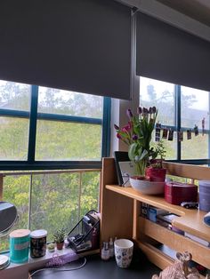 a room with two large windows and various items on the table