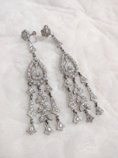 These earrings are to DIE for!! These stunning beautiful pieces are authentic 1920s art deco rhinestone. The silver tone pot metal is loaded with rhinestones and has a screw back style. These are SUPER long and GORGEOUS!! These are PERFECT for the Gatsby wedding or themed event. Please see all pictures on this pair for a better description and sizing. 13 Formal Silver Chandelier Earrings With 17 Jewels, Victorian Screw Back Wedding Jewelry, Victorian Screw Back Earrings For Wedding, Victorian Screw Back Wedding Earrings, Victorian Wedding Earrings With Screw Back, Victorian Silver Bridal Earrings For Formal Events, Vintage White Gold Earrings For Wedding, Victorian Silver Bridal Earrings For Formal Occasions, Vintage Dangle Jewelry With Diamond Accents