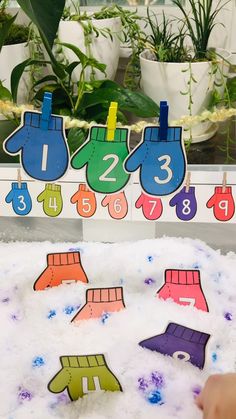 there is a snow covered table with numbers on it and magnets in the shape of mittens