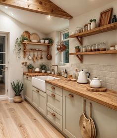 a kitchen filled with lots of counter top space and wooden shelves next to a door