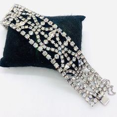 Gorgeous wide sparkling clear rhinestone bracelet. Rhodium plated metal securely prong with clear rhinestones in a lacy filigree design. In excellent vintage condition with minimal age appropriate wear. Push in box clasp secure. Has it's original safety chain. Measures 7 1/2 inches long by 1 1/4 inches wide. Glamorous Silver Crystal Bracelet With Rhinestones, Glamorous Crystal Bracelets With Rhinestones, Silver Crystal Bracelet With Diamond Accents, Dazzling Crystal Bracelets With Rhinestones, Dazzling Rhinestone Crystal Bracelets, Glamorous Crystal Bracelet With Rhinestones, Diamond White Tennis Bracelet For Party, Dazzling Diamond White Bracelets With Rhinestones, Dazzling Diamond White Bracelet With Rhinestones