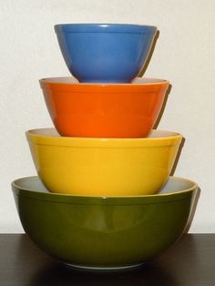 four different colored bowls stacked on top of each other