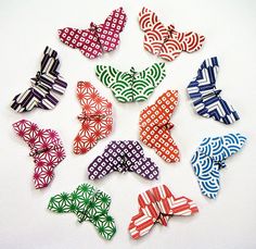 many different colored bows on a white surface with black and red designs in the middle