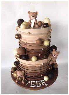 a three tiered cake decorated with teddy bears and chocolate candies on the top